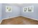 Corner bedroom featuring hardwood floors, two windows, baseboard trim and blue walls at 3664 Pin Oak Cir, Atlanta, GA 30340