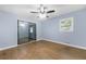 This light blue bedroom features hardwood floors, a ceiling fan, window, and a sliding glass door at 3664 Pin Oak Cir, Atlanta, GA 30340