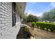 Landscaped front yard with flowering garden, brick accents, and a driveway under a cloudy sky at 3664 Pin Oak Cir, Atlanta, GA 30340