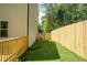 Backyard view showing a new fence, a small patch of grass, and access to the deck at 4366 Bradley Sw Dr, Snellville, GA 30039