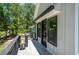Spacious balcony features gray wood-look tile, black railings, and stylish black framed windows and doors at 4366 Bradley Sw Dr, Snellville, GA 30039