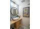 Stylish powder room features a unique sink, round mirror and decorative wall art at 4366 Bradley Sw Dr, Snellville, GA 30039