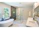 This luxurious bathroom has double sinks, a soaking tub, and a glass shower with a marble surround at 4366 Bradley Sw Dr, Snellville, GA 30039