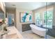 Bright bathroom features double sinks, a standalone tub, a shower, and views through two large windows at 4366 Bradley Sw Dr, Snellville, GA 30039