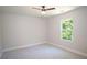 Empty bedroom with neutral walls, carpet flooring, a ceiling fan, and a view out of a large window at 4366 Bradley Sw Dr, Snellville, GA 30039