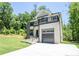 Beautifully landscaped modern home with balcony, grey garage door, and inviting curb appeal at 4366 Bradley Sw Dr, Snellville, GA 30039