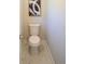 Neutral half-bathroom with white toilet, white walls and marbelized tile flooring at 4366 Bradley Sw Dr, Snellville, GA 30039