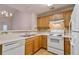 Functional kitchen with oak cabinets, white appliances, and adjacent dining area at 184 Darbys Crossing Ct, Hiram, GA 30141