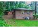 Exterior shot of a brick house with a lush green yard and an adjacent building at 2046 Rector Sw Dr, Atlanta, GA 30311
