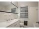 Cozy bathroom with tiled walls, a window, and a well-lit mirror above the sink at 2046 Rector Sw Dr, Atlanta, GA 30311