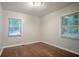 Small, bright bedroom with hardwood floors and natural light from two windows at 2046 Rector Sw Dr, Atlanta, GA 30311