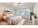 This is a staged bedroom with neutral colors, a ceiling fan and an abundance of light from multiple windows at 2218 Lowtrail Ct, Lithonia, GA 30058