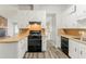 Functional kitchen with white cabinets, laminate countertops, black appliances, and modern flooring at 2218 Lowtrail Ct, Lithonia, GA 30058