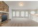 Spacious living room with a stone fireplace, carpet flooring, and several windows that provide natural light at 2218 Lowtrail Ct, Lithonia, GA 30058