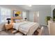 Staged bedroom with two windows, white comforter, and light wood furniture at 2239 Carey Se Dr, Atlanta, GA 30315