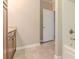 Bathroom with tan, tiled floors and open door that leads to another room at 2378 Randall Ave, Lithonia, GA 30058