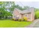 A charming, light pink home featuring manicured landscaping and verdant greenery on a cloudy day at 2378 Randall Ave, Lithonia, GA 30058