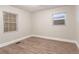 A minimalist bedroom features two windows with mini blinds and gray wood-look flooring providing ample natural light at 2817 Burton Nw Rd, Atlanta, GA 30311
