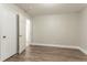 A minimalist bedroom features gray wood-look floors and two white doors leading to the closet and entry at 2817 Burton Nw Rd, Atlanta, GA 30311