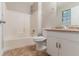 Clean bathroom featuring a shower-tub combo, toilet, and vanity with modern fixtures at 5218 Tina Ct, Stone Mountain, GA 30083