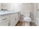 Bathroom with standard white toilet and vanity featuring dated countertops and flooring at 5218 Tina Ct, Stone Mountain, GA 30083