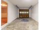 One car garage with concrete floor and door leading into an adjacent carpeted room at 5218 Tina Ct, Stone Mountain, GA 30083
