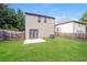 A large backyard with green grass, a patio, and a wooden fence at 545 Offaly Ln, Atlanta, GA 30349