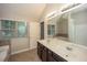 This bathroom features a double sink vanity, a large window, and a tub at 545 Offaly Ln, Atlanta, GA 30349