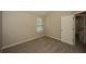 This carpeted bedroom features a window for plenty of natural light and neutral walls at 545 Offaly Ln, Atlanta, GA 30349