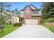 Charming two-story home features a brick facade, two-car garage, and a well-manicured lawn at 545 Offaly Ln, Atlanta, GA 30349