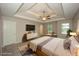 This main bedroom features a tray ceiling, a ceiling fan, and a large window at 545 Offaly Ln, Atlanta, GA 30349