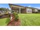 Landscaped backyard features lush lawn, a covered porch, and a retaining wall with tasteful plantings, perfect for outdoor enjoyment at 2012 Ripple Park Bend, Canton, GA 30114