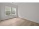 Bright bedroom featuring two windows, light wood flooring, white walls, and trim at 2012 Ripple Park Bend, Canton, GA 30114