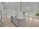 Bright kitchen with island featuring modern lighting, sink, cabinets, and stainless steel appliances at 2012 Ripple Park Bend, Canton, GA 30114
