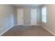 Neutral bedroom showcasing plush carpeting, a window for natural light, and two closets for ample storage at 2654 Laurel View Dr, Snellville, GA 30039