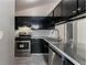 Modern kitchen featuring granite counters, stainless steel appliances, and dark cabinets at 2654 Laurel View Dr, Snellville, GA 30039