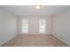 Empty bedroom with two windows and neutral colored walls and carpet at 2799 Lake Jodeco Rd, Jonesboro, GA 30236