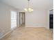 Neutral dining area featuring tile floors, modern chandelier, and a view of the front door at 2799 Lake Jodeco Rd, Jonesboro, GA 30236