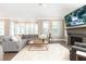 Spacious living room featuring fireplace, large windows, and comfortable gray seating at 3900 Danube Ln, Atlanta, GA 30339