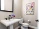 Elegant powder room featuring pedestal sink, modern fixtures, and colorful artwork at 3900 Danube Ln, Atlanta, GA 30339