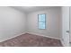 This is a simply designed carpeted bedroom with a window providing natural light at 4766 White Oak Path, Stone Mountain, GA 30088