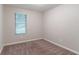 Bedroom featuring neutral walls, plush carpet, and a window for natural light at 4766 White Oak Path, Stone Mountain, GA 30088