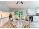 Bright dining area features a modern glass table, white chairs, and sliding doors to the outdoor space at 4766 White Oak Path, Stone Mountain, GA 30088