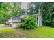 A two-story home showcasing a stone facade, attached garage, and lush landscaping, with green trees at 4766 White Oak Path, Stone Mountain, GA 30088