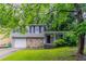 Charming split-level home with a stone facade, attached garage, and a well-manicured lawn at 4766 White Oak Path, Stone Mountain, GA 30088