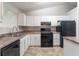 Efficient kitchen featuring black appliances, ample white cabinetry, and a convenient layout at 4766 White Oak Path, Stone Mountain, GA 30088