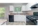 Functional kitchen featuring black appliances, abundant white cabinetry, and an outside view at 4766 White Oak Path, Stone Mountain, GA 30088
