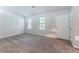 An empty room showcases new carpet, large windows, and a white door with neutral paint at 4766 White Oak Path, Stone Mountain, GA 30088