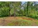 View of the lush backyard with mature trees, open space, and potential for outdoor activities and landscaping at 6535 Buckhurst Trl, Atlanta, GA 30349