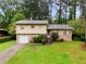 Charming two-story home with a well-maintained front yard and traditional design, set against a backdrop of mature trees at 6535 Buckhurst Trl, Atlanta, GA 30349